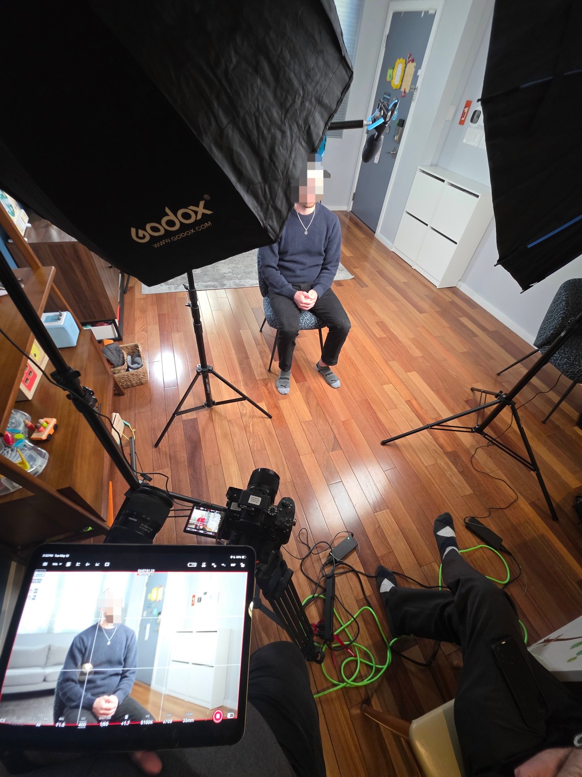 Behind the scenes of an interview with softbox lighting and a camera monitor