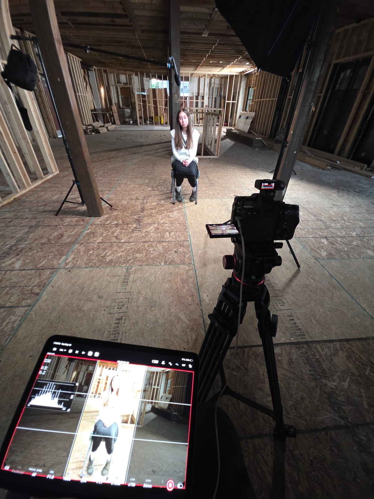 An interview setup on location with a camera, monitor, and boom microphone