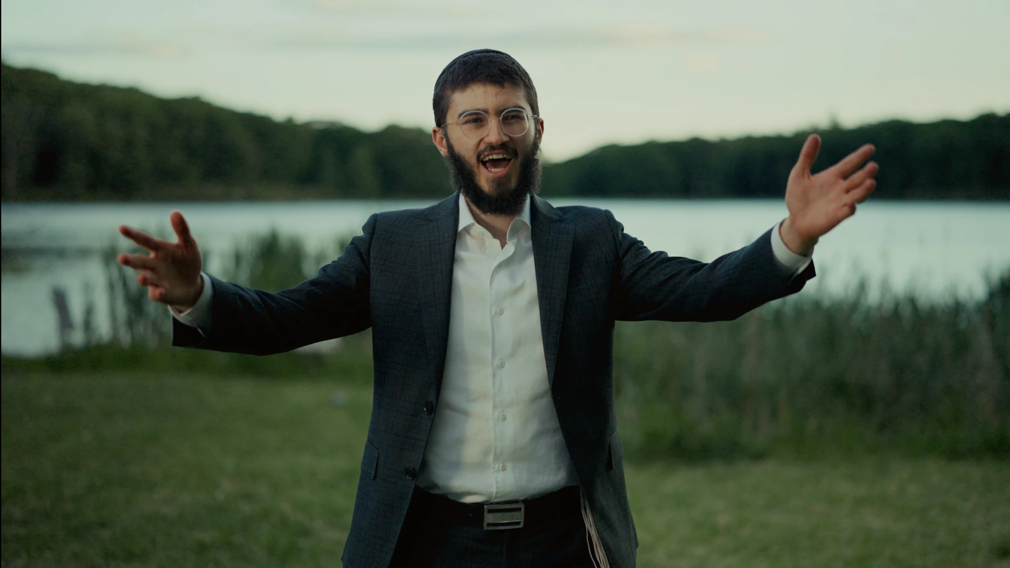 A singer performing outdoors beside a lake