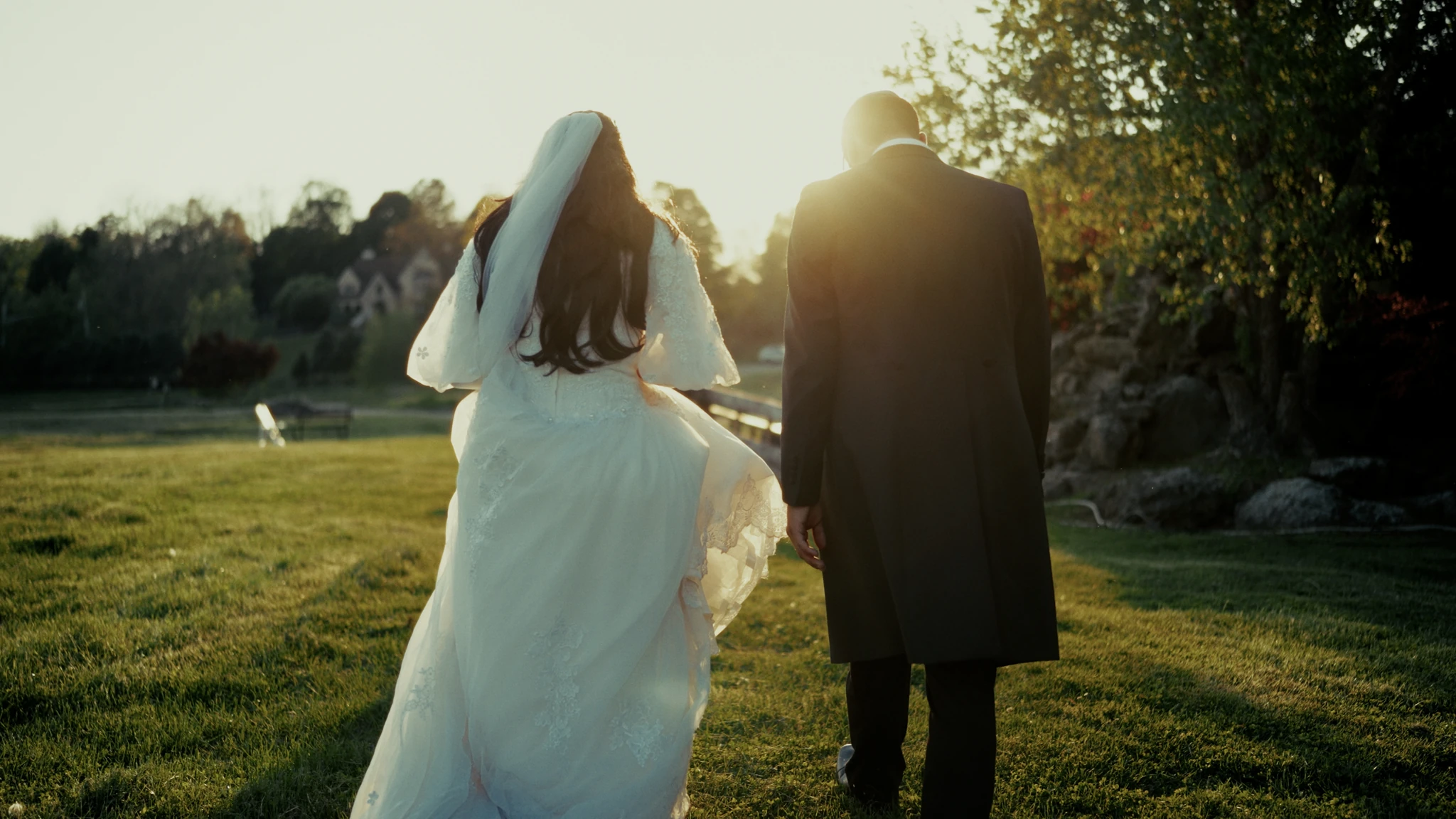 A bride and groom walking together in warm evening light